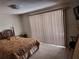 Bedroom featuring a large window, neutral walls, and a patterned comforter on the bed at 3206 Pinon Dr, Holiday, FL 34691