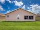 Backyard view of home with manicured lawn and a neutral-colored exterior at 3317 Abigail Ct, New Port Richey, FL 34655