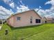 Manicured backyard featuring a neutral-colored home with well-maintained lawn and landscaping at 3317 Abigail Ct, New Port Richey, FL 34655