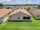 This backyard features a lush lawn, complemented by a neutral-toned exterior and a well-maintained roof at 3317 Abigail Ct, New Port Richey, FL 34655