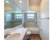 Bathroom featuring neutral tile, a white vanity, a large mirror, and a shower-tub combo at 3317 Abigail Ct, New Port Richey, FL 34655
