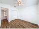 Bright bedroom featuring wood-look floors, ceiling fan, and a closet for ample storage space at 3317 Abigail Ct, New Port Richey, FL 34655