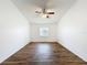 Bedroom with wood-look floors, a fan-light fixture, and bright window at 3317 Abigail Ct, New Port Richey, FL 34655