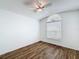 Bedroom features wood flooring, a ceiling fan, neutral paint, and an arched window at 3317 Abigail Ct, New Port Richey, FL 34655