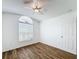 Bright bedroom featuring wood-look floors, a fan-light fixture, and a large window at 3317 Abigail Ct, New Port Richey, FL 34655