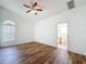 Bright bedroom featuring wood-look floors, ceiling fan, and an attached bathroom at 3317 Abigail Ct, New Port Richey, FL 34655