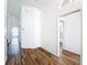 Hallway leading to the bathroom and secondary bedrooms featuring wood flooring and neutral paint at 3317 Abigail Ct, New Port Richey, FL 34655