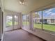 Enclosed lanai with neutral carpet features a ceiling fan and sliding glass door to the backyard at 3317 Abigail Ct, New Port Richey, FL 34655