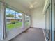 Bright lanai with neutral carpet, ceiling fan, and view of the manicured backyard at 3317 Abigail Ct, New Port Richey, FL 34655