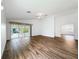 Living room showcases wood flooring, ceiling fan, neutral paint, and sliding door access to the enclosed porch at 3317 Abigail Ct, New Port Richey, FL 34655