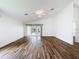 Living room boasts wood flooring, ceiling fan, neutral paint, and sliding door access to the enclosed porch at 3317 Abigail Ct, New Port Richey, FL 34655