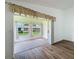 View of sunroom with windows overlooking green space and exterior buildings at 3317 Abigail Ct, New Port Richey, FL 34655