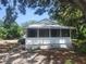 Charming cottage-style home featuring a screened-in front porch and mature trees providing ample shade at 3415 N 51St St, Tampa, FL 33619