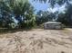 Cottage-style home with a large, sandy front yard and mature trees at 3415 N 51St St, Tampa, FL 33619