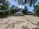 Cottage-style home with a large, sandy front yard and mature shade trees at 3415 N 51St St, Tampa, FL 33619