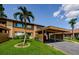 Charming condo exterior featuring a carport, palm tree, well-manicured lawn, and American flag at 3841 Lanyard Ct # B, New Port Richey, FL 34652