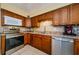 Updated kitchen with modern appliances and warm wood cabinets and tile backsplash at 3841 Lanyard Ct # B, New Port Richey, FL 34652