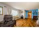Bright living area with wood floors, blue accent wall and comfy gray recliner at 3841 Lanyard Ct # B, New Port Richey, FL 34652