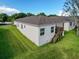Rear view of the property showing the back of the house, green lawn, and porch, perfect for outdoor enjoyment at 4082 Watson Dr, New Port Richey, FL 34655