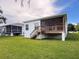 Large backyard with covered porch and wood deck overlooking the lush green lawn at 4082 Watson Dr, New Port Richey, FL 34655