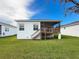 Back exterior view of home with a wooden staircase, a covered patio, and a well-manicured lawn at 4082 Watson Dr, New Port Richey, FL 34655