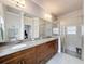 Bathroom featuring a double vanity, granite countertop, tile flooring and glass enclosed shower at 4082 Watson Dr, New Port Richey, FL 34655