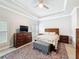 Cozy bedroom featuring a tray ceiling, windows with shutters, a bed and an area rug at 4082 Watson Dr, New Port Richey, FL 34655