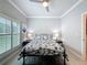 The light and bright bedroom includes window shutters, wood look floors, and neutral walls at 4082 Watson Dr, New Port Richey, FL 34655