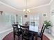 Bright dining room featuring a dining set, a chandelier, and multiple windows with shutters at 4082 Watson Dr, New Port Richey, FL 34655