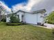 Exterior view of a well-maintained, single-story home with green lawn and flower bed at 4082 Watson Dr, New Port Richey, FL 34655