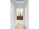 Hallway view into a well-lit primary bathroom featuring double vanities and tile flooring at 4082 Watson Dr, New Port Richey, FL 34655