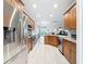 Well-lit kitchen features stainless appliances, wooden cabinetry, and bright tile flooring at 4082 Watson Dr, New Port Richey, FL 34655