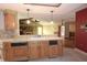 Open-concept kitchen with wood cabinets, tile backsplash, and serving counter to living area at 4269 River Birch Dr, Spring Hill, FL 34607