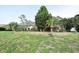 Backyard showing screened-in pool area, mature trees, and landscaping, enhancing outdoor living at 4269 River Birch Dr, Spring Hill, FL 34607