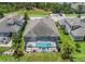 Aerial view of the backyard featuring a screened in pool, lush landscaping and well manicured backyard at 4287 Woodland Retreat Blvd, New Port Richey, FL 34655