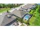 Aerial view of the home with a screened-in pool and patio area, surrounded by lush landscaping at 4287 Woodland Retreat Blvd, New Port Richey, FL 34655