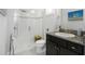 Modern bathroom featuring a glass-enclosed shower, dark wood vanity, and neutral tile for a clean design at 4287 Woodland Retreat Blvd, New Port Richey, FL 34655