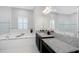 All-white bathroom boasting granite counters, dark cabinets, soaking tub, and tile flooring at 4287 Woodland Retreat Blvd, New Port Richey, FL 34655