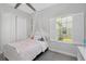 Cozy bedroom featuring a canopy bed, soft lighting, and a large window with white shutters at 4287 Woodland Retreat Blvd, New Port Richey, FL 34655