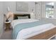 Comfortable bedroom with a stylish bed, decorative artwork, and lots of natural light from the nearby window at 4287 Woodland Retreat Blvd, New Port Richey, FL 34655