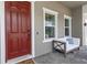 Inviting front porch with a cozy seating area and a view of the beautifully landscaped yard at 4287 Woodland Retreat Blvd, New Port Richey, FL 34655