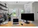 Bright home office with modern decor, large windows with plantation shutters, and sleek desk setup at 4287 Woodland Retreat Blvd, New Port Richey, FL 34655