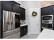 Modern kitchen featuring stainless steel refrigerator, black cabinets, and stylish decor at 4287 Woodland Retreat Blvd, New Port Richey, FL 34655