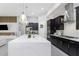 Stunning kitchen with a white quartz island, dark cabinets, gold hardware, and modern light fixtures at 4287 Woodland Retreat Blvd, New Port Richey, FL 34655