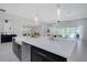 Kitchen island with white countertop and stainless steel appliances, adjoining a bright living space at 4287 Woodland Retreat Blvd, New Port Richey, FL 34655