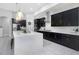 Elegant kitchen featuring sleek black cabinetry, modern appliances, quartz countertops, and stylish pendant lighting at 4287 Woodland Retreat Blvd, New Port Richey, FL 34655