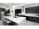 Spacious kitchen featuring a large island with seating, dark cabinets, and stainless steel appliances at 4287 Woodland Retreat Blvd, New Port Richey, FL 34655