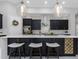Beautiful kitchen island with bar seating, pendant lights, black cabinets, and stainless steel appliances at 4287 Woodland Retreat Blvd, New Port Richey, FL 34655