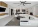 Large living room seamlessly connects with a modern kitchen and features sleek, neutral-toned tile flooring at 4287 Woodland Retreat Blvd, New Port Richey, FL 34655