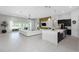 Expansive living space showcasing a modern kitchen island, sleek furnishings, and seamless indoor-outdoor flow at 4287 Woodland Retreat Blvd, New Port Richey, FL 34655